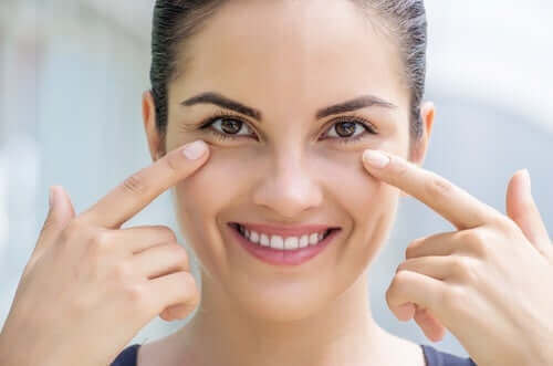 Kobieta ze zdrową skórą dotyka skóry pod oczami