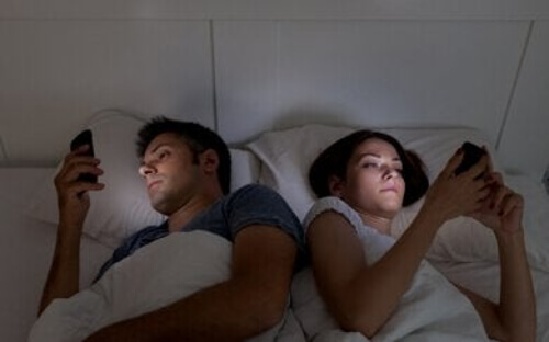 Para w łóżku z telefonami