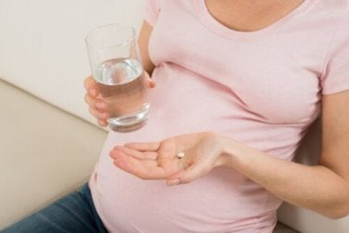 Kobieta w ciąży połyka tabletkę