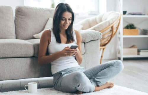 Kobieta patrząca na telefon - zespół text neck