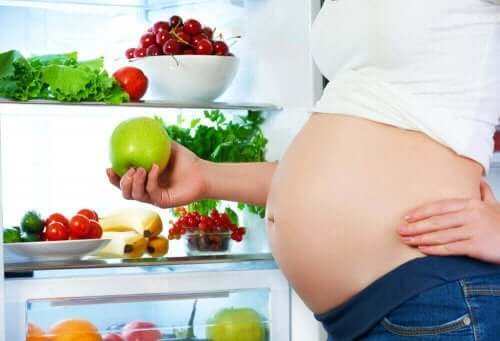 Kobieta w ciąży trzymająca jabłko - dieta w ciąży