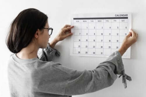Kobieta wieszająca kalendarz na ścianie