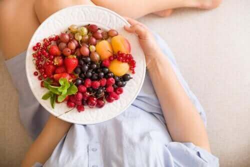Kobieta w ciąży z talerzem owoców - jedzenie w ciąży