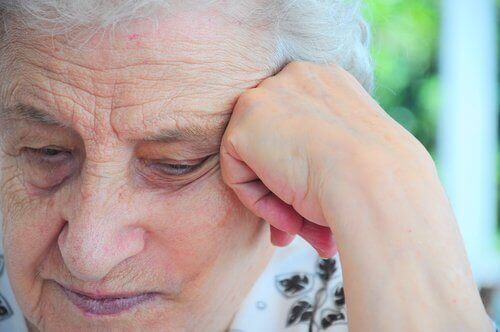 Starsza kobieta podpiera głowę, pielęgnacja głosu