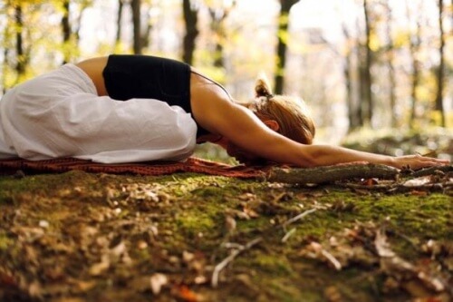 Kobieta uprawiająca medytację w lesie