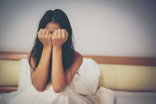 Płacząca kobieta w łóżku - znęcanie się psychiczne