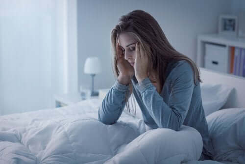 Zmęczona kobieta w łóżku - zaburzenia związane z bezsennością