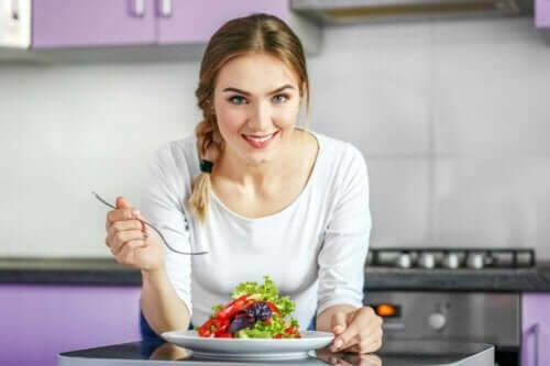 Kobieta z sałatką - co warto zrobić przed rozpoczęciem diety wegańskiej