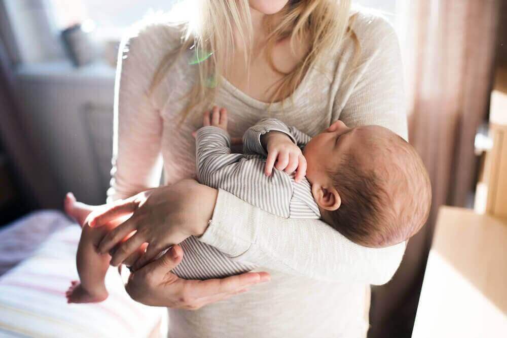 Mama trzymająca niemowlę - materiały na ubranka dla niemowląt