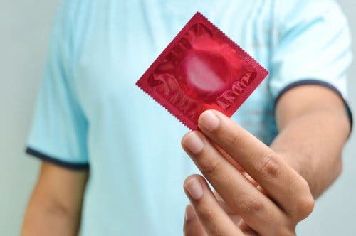 Mężczyzna trzymający prezerwatywę