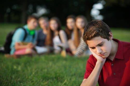 Siedzący sam nastolatek - presja równieśnicza
