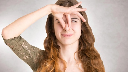 Kobieta zatykająca nos