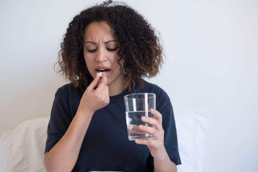 Kobieta połykająca tabletkę