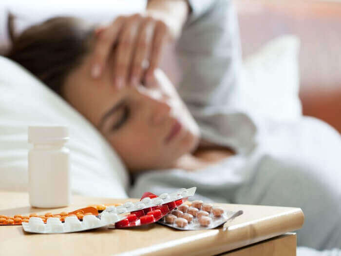Kobieta w łóżku z tabletkami