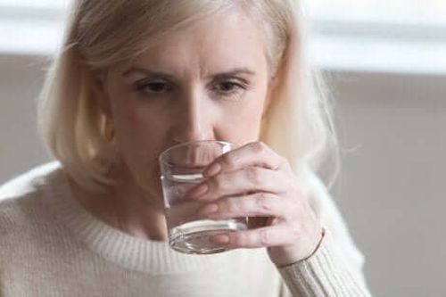 Starsza kobieta pije wodę ze szklanki
