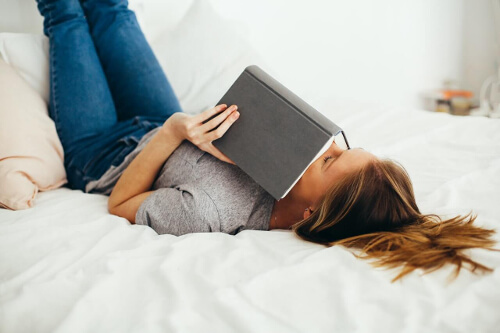 Kobieta z książką na łóżku