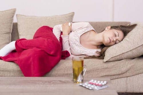 Kobieta z bólem brzucha leżąca na kanapie