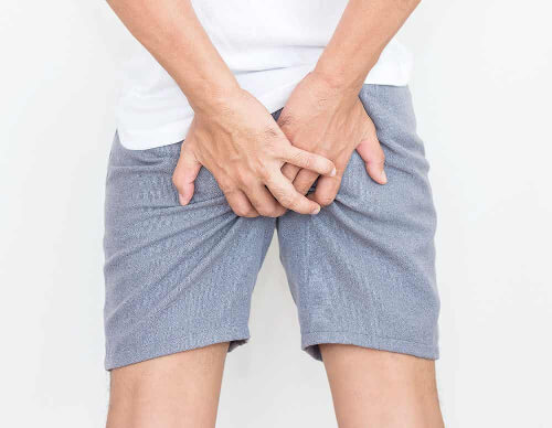Mężczyzna drapie się po pośladkach