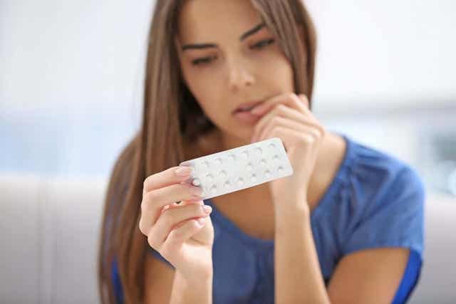 Kobieta trzymająca tabletki antykoncepcyjne